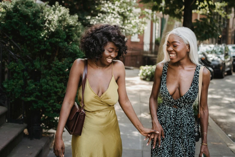 two african american women hold hands on the street