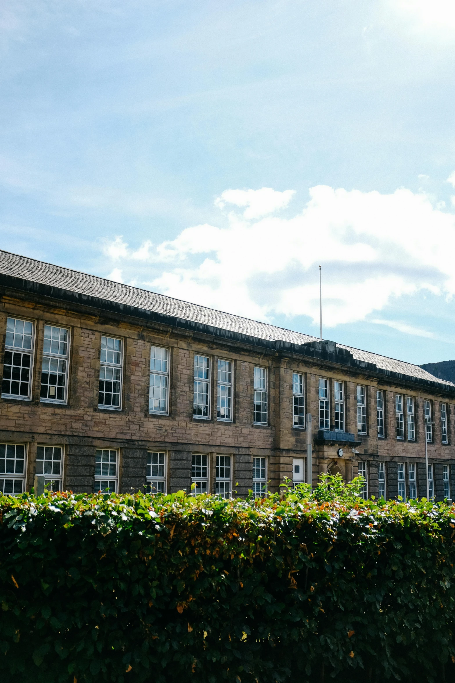 the top of a building stands behind hedges