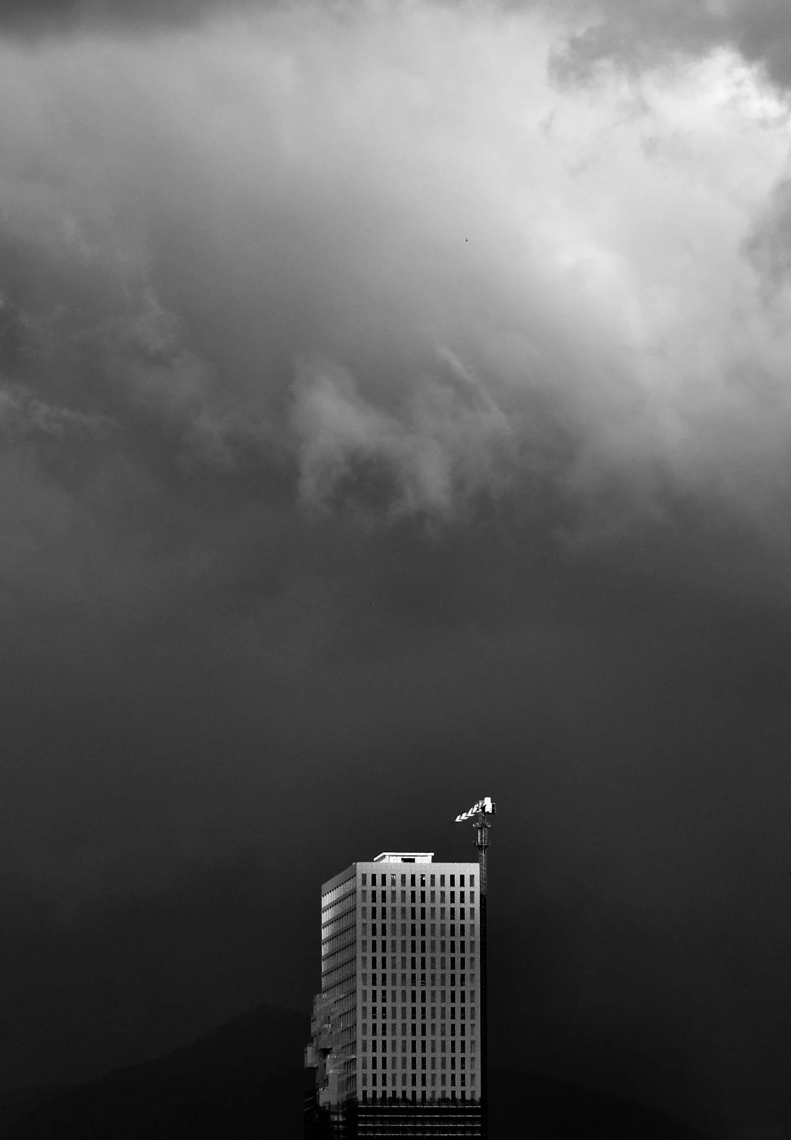 a bird flies over the top of an office building under clouds