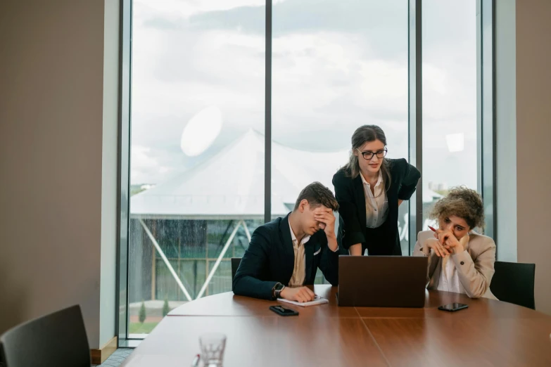 two business people are in a conference room and look at a computer