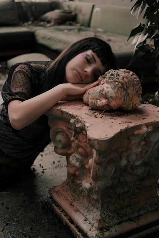 a person with their face resting on a rock