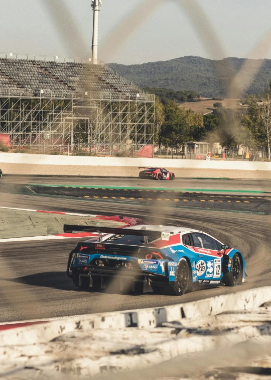 two race cars with the number 19 in blue are turning around the track