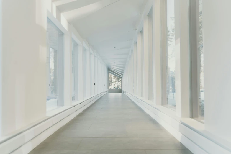 a long hallway with windows leading to a building