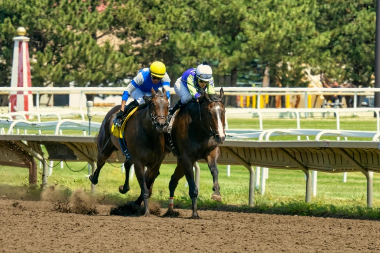 jockeys are riding horses around the track