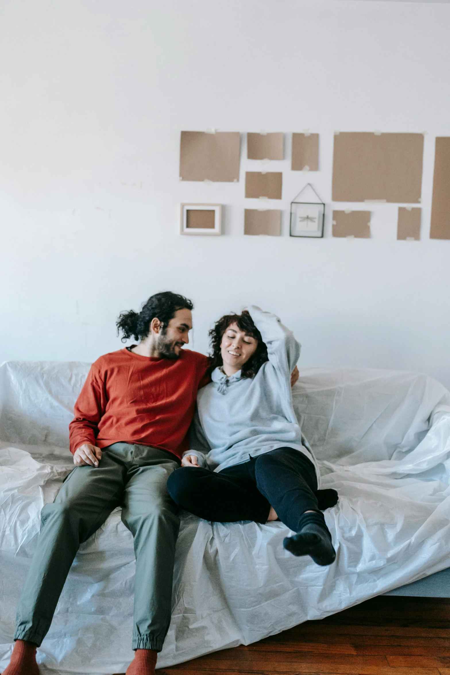 a man and woman laying on a bed with sheets