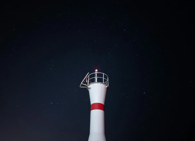 a very tall light house at the top of a hill