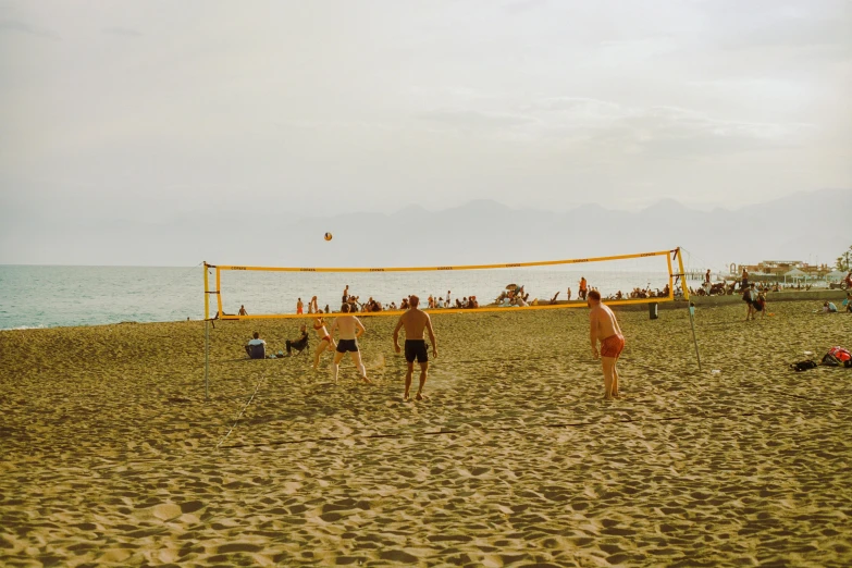 two men playing volleyball on a beach