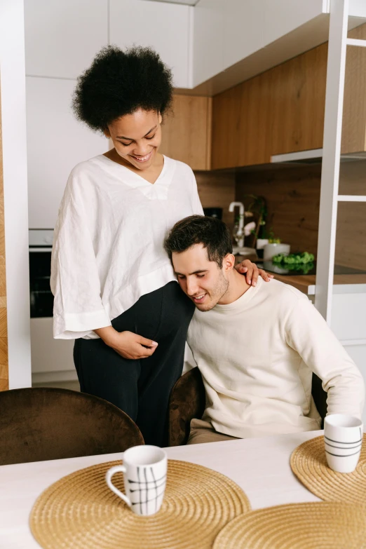 man and woman sitting at kitchen counter, looking at plate