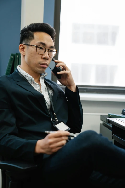 an asian man talking on a cell phone