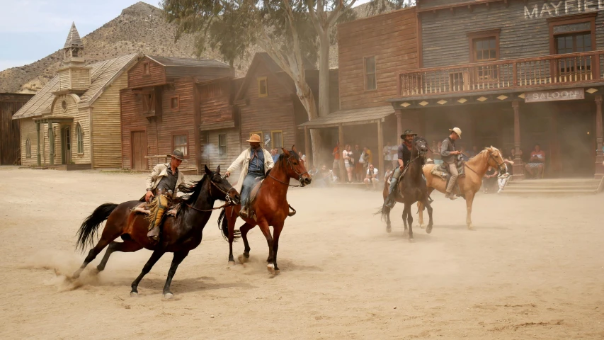 two men are racing on horses in front of a town