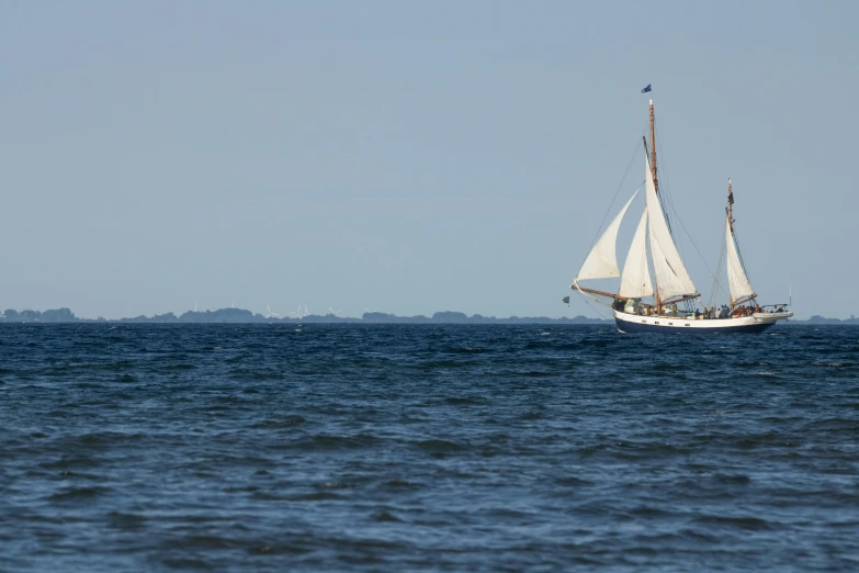 a sailboat with sails is moving in the water