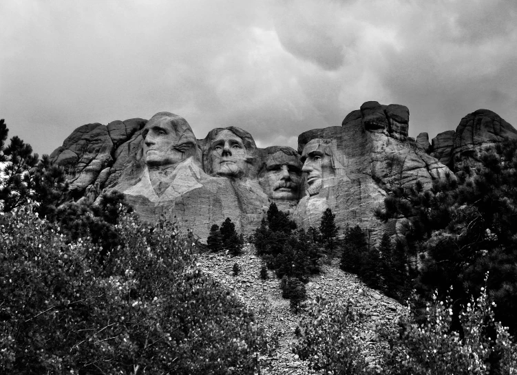 black and white pograph of mount rush, face - shaped mountains, and evergreen trees