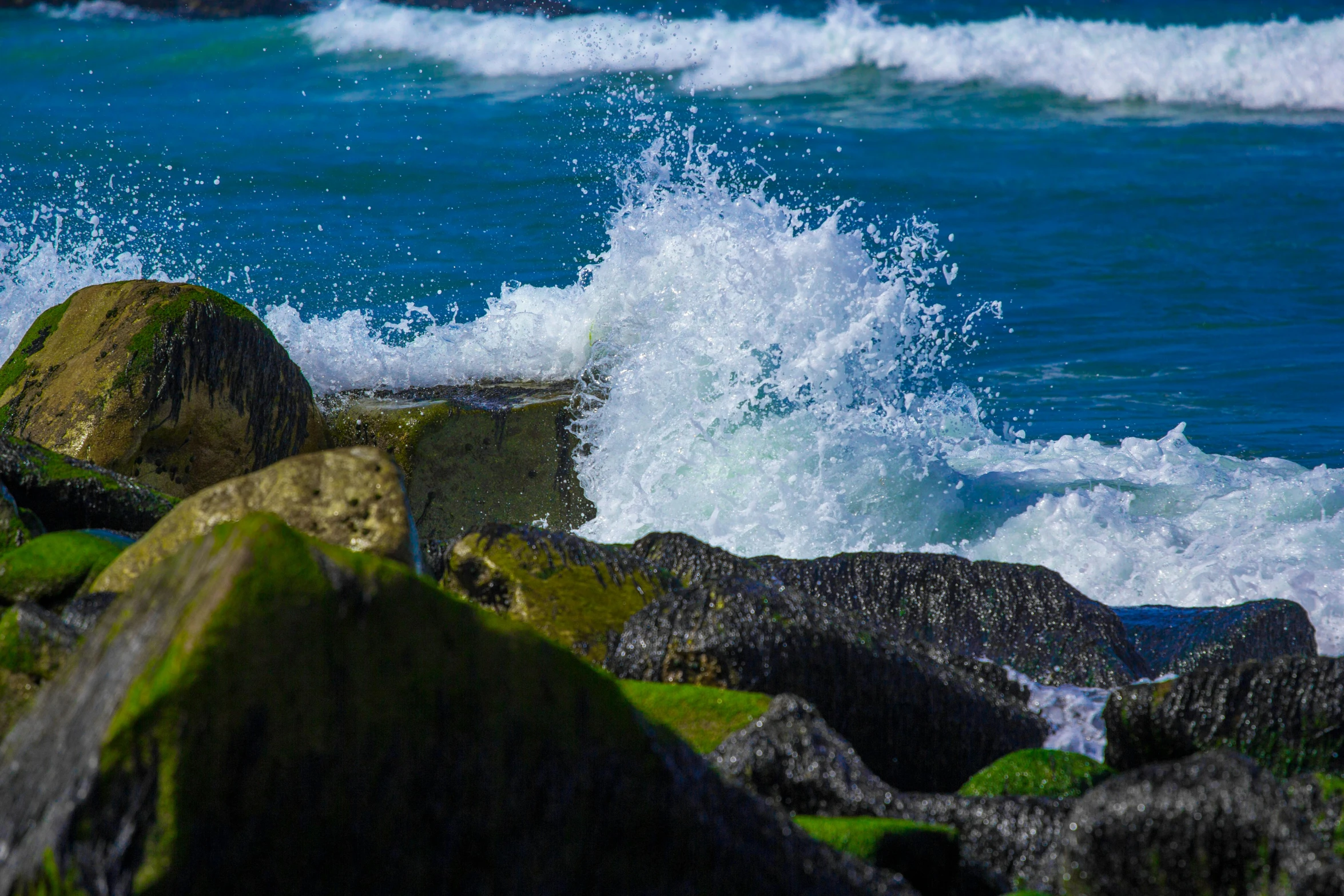 a body of water splashing over some rocks