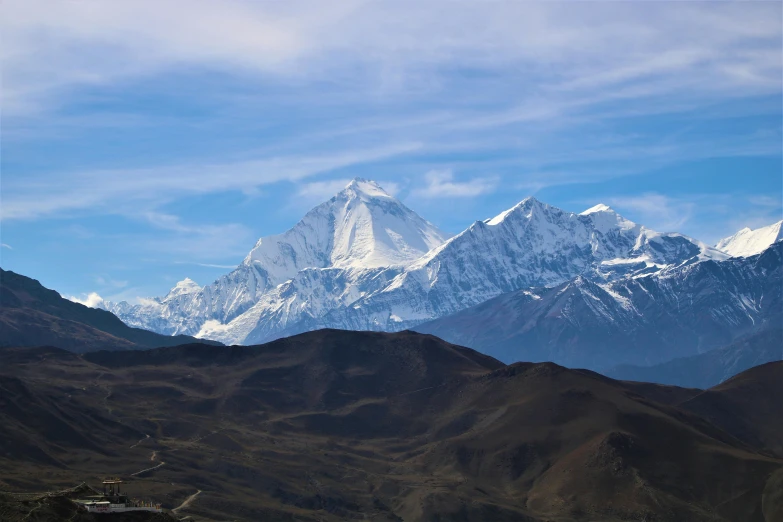 a mountain with snow capped top against a blue sky