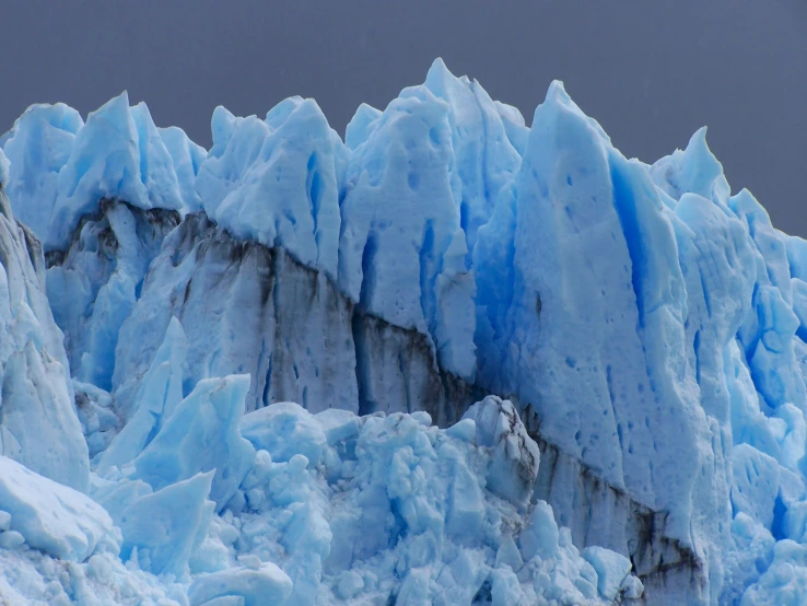 a large glacier with a snow covered mountain in the background