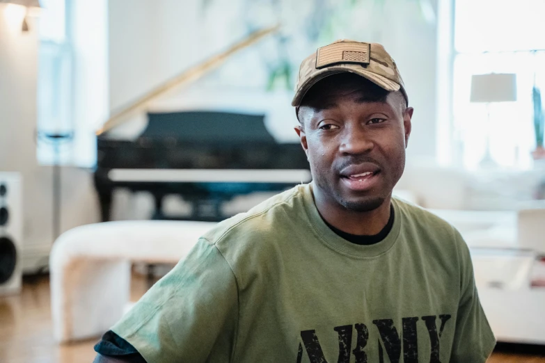 a man in a green shirt sitting at a table with a piano