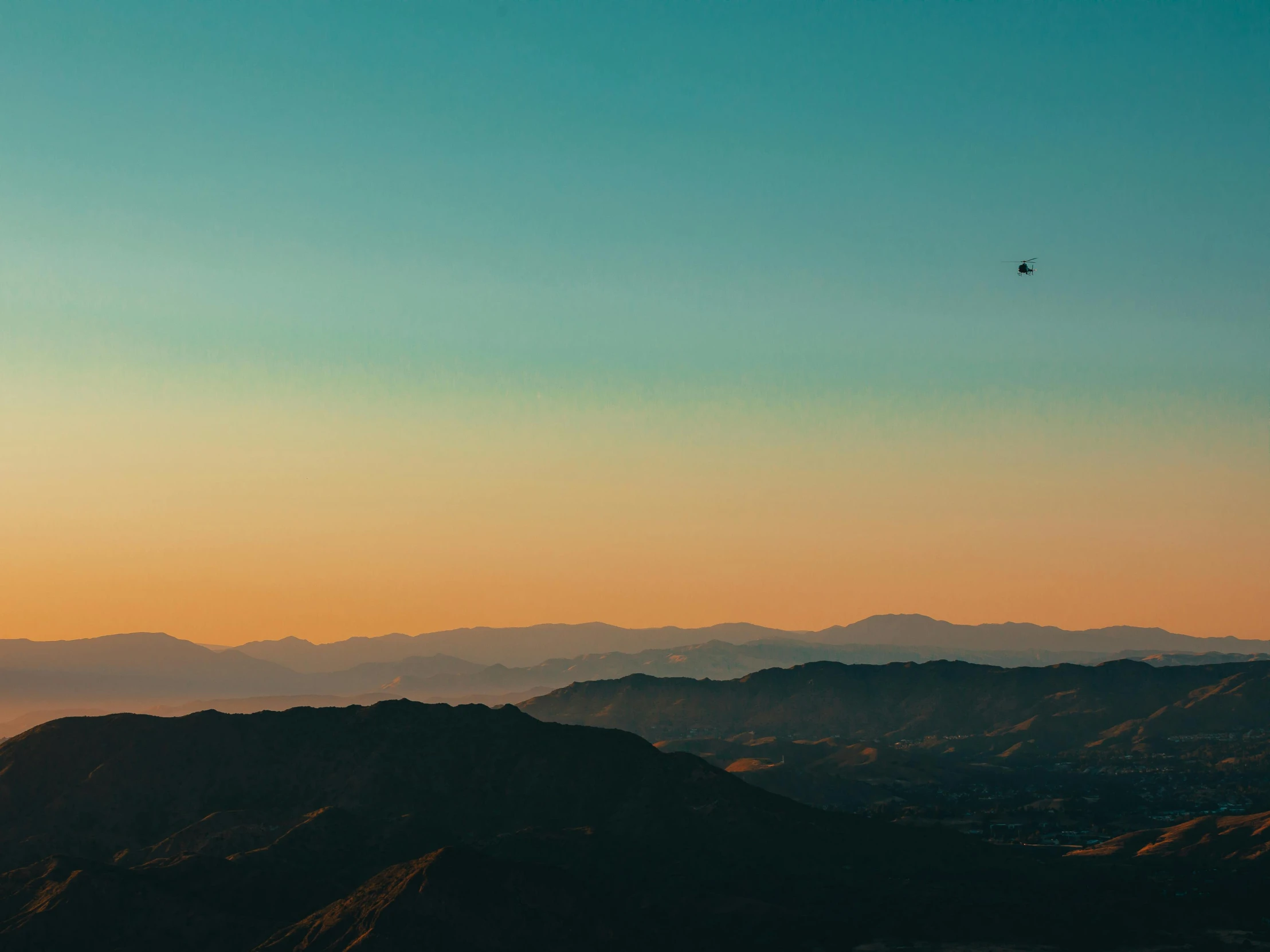 an airplane is flying in the distance over a hill