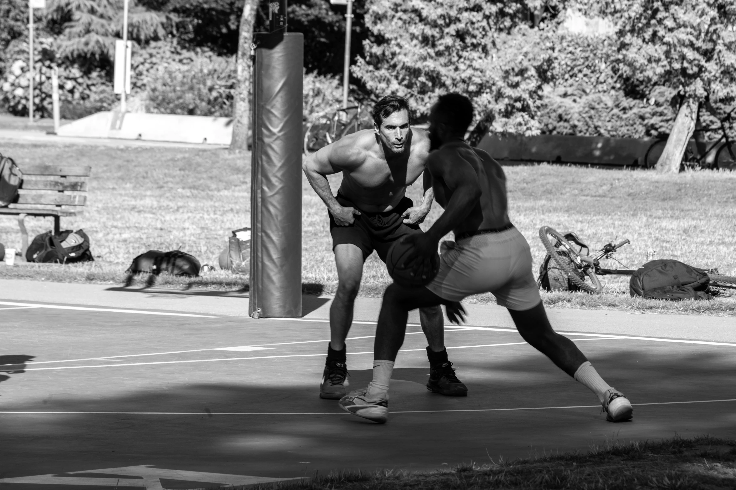 two men in a public park playing basketball