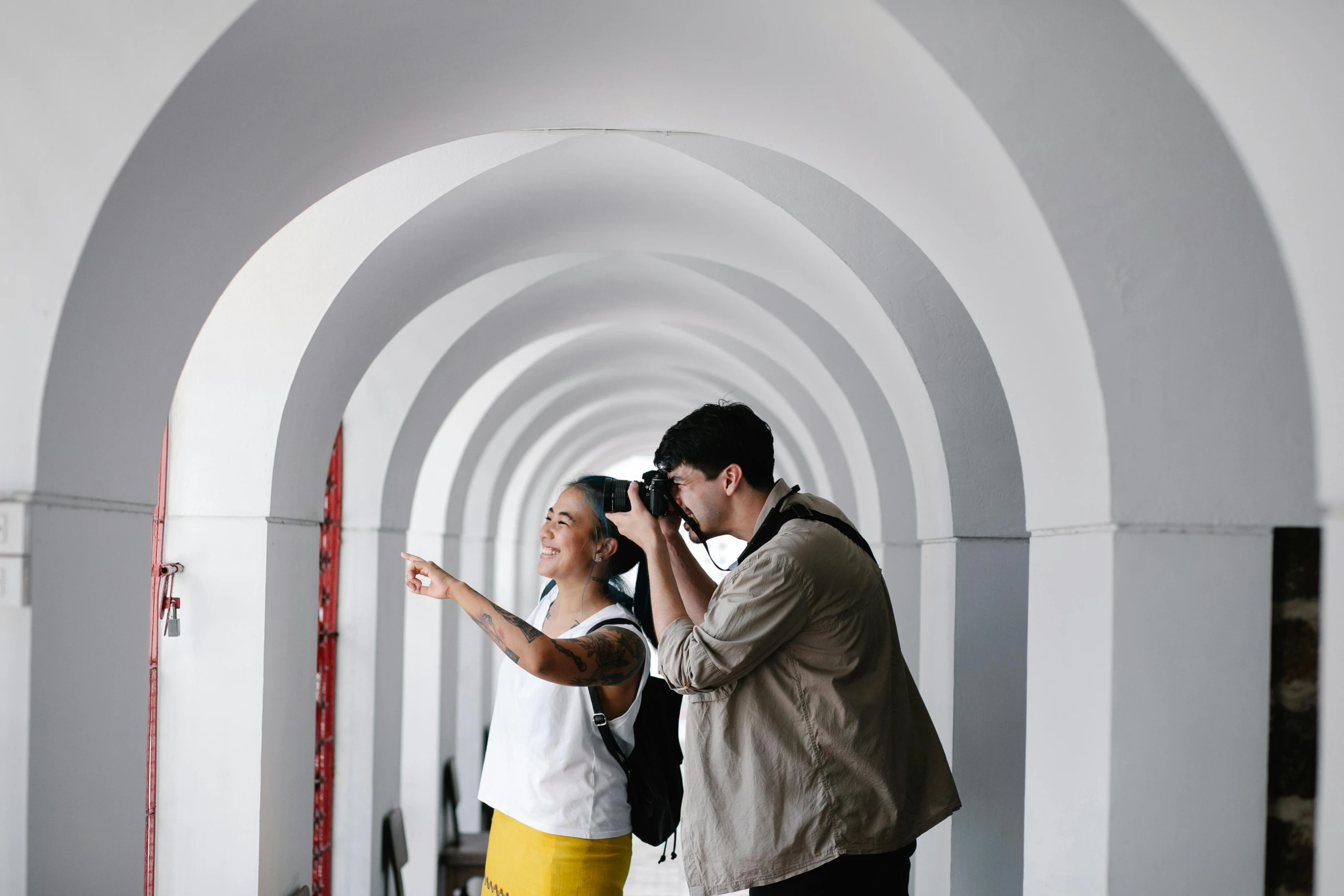 two people that are standing together by some arches