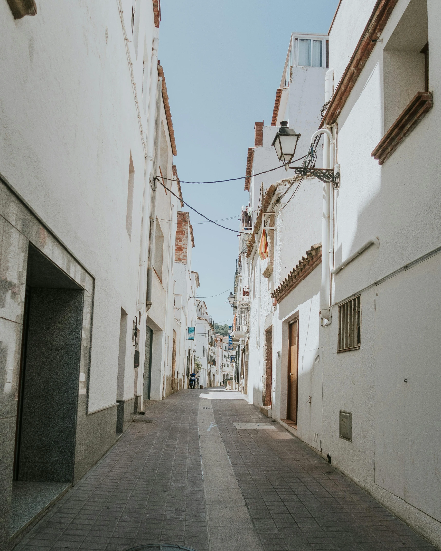 a narrow street with white buildings along it