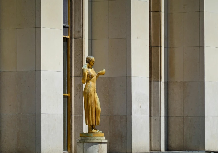 an statue of lady liberty in front of a wall