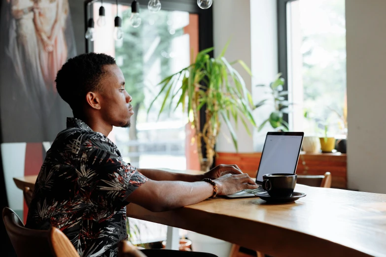 a man is using his laptop on the table