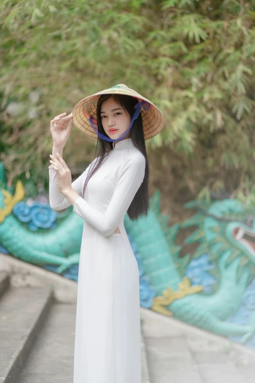 a woman wearing a hat posing in front of a mural