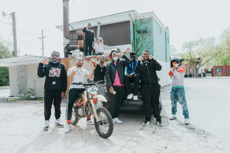 a group of people standing in front of a motorbike