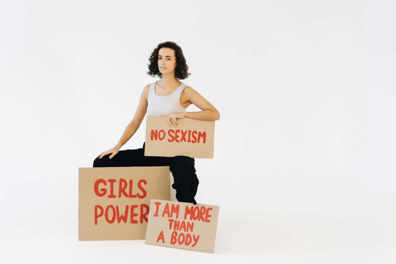 two women are posing while holding cardboard signs