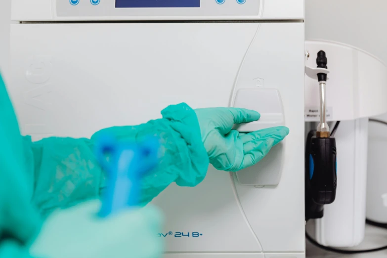 two gloves hanging on a white machine with blue writing