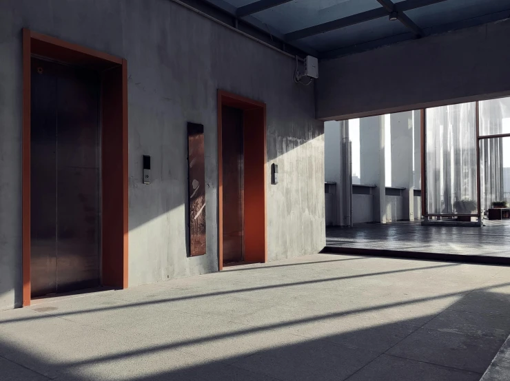 three red doors in a courtyard next to an outside building