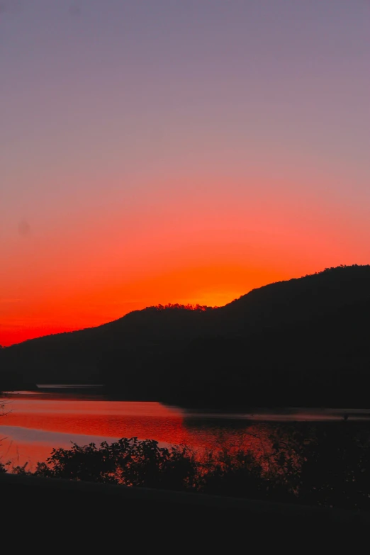 a body of water that has some hills in the background