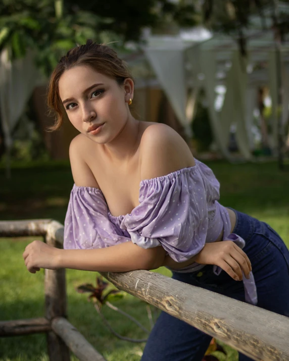 the young woman is leaning on a fence