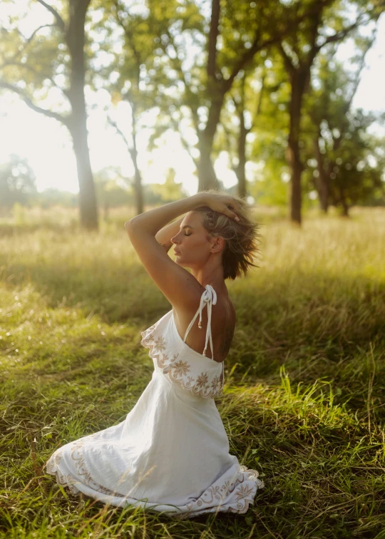 the woman is sitting down in a field