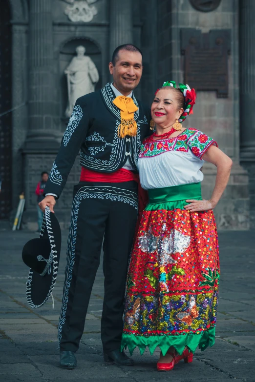 a woman standing next to a man wearing a colorful dress