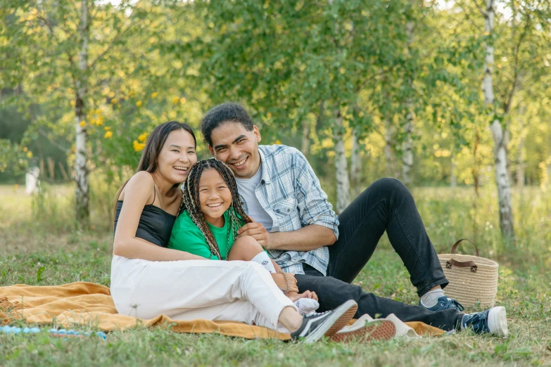 a family of four sits together in a grassy field