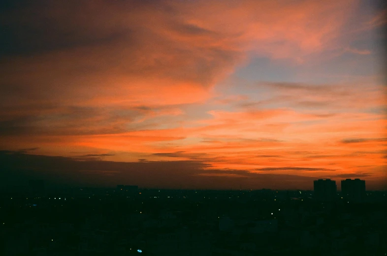 bright orange sky at dusk with city lights