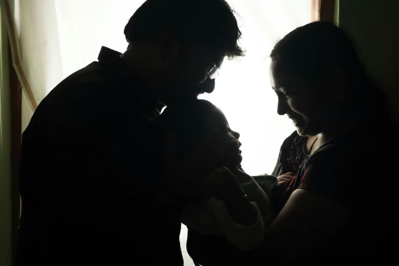 a man and woman are holding a baby