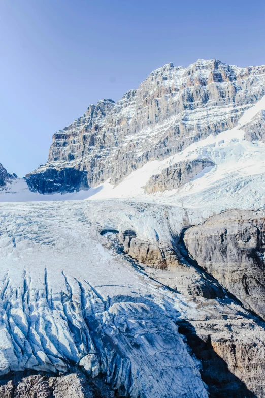 a large glacier with rocks and mountains in the background