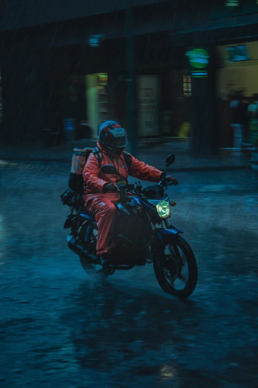 a man riding a motorcycle in the rain with an umbrella on the back of it
