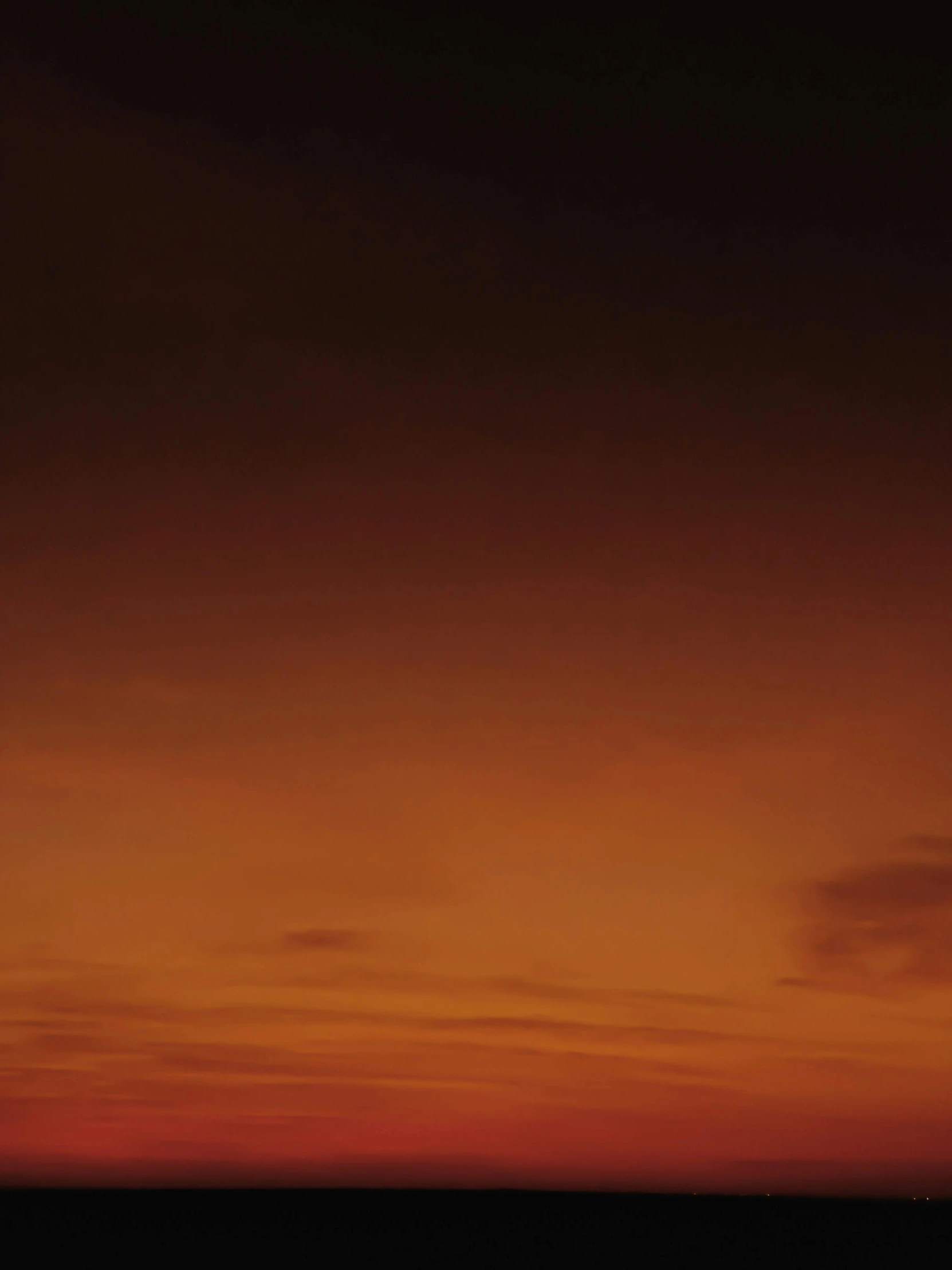 a airplane in a cloudy sunset with red clouds