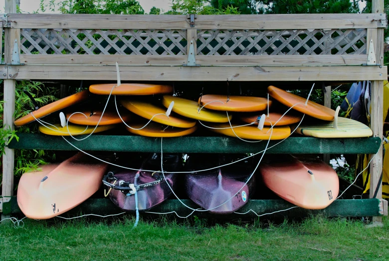 a bunch of kayaks and kayaks in a wooden storage