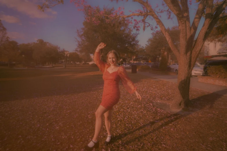 a woman posing in a dress outside near trees