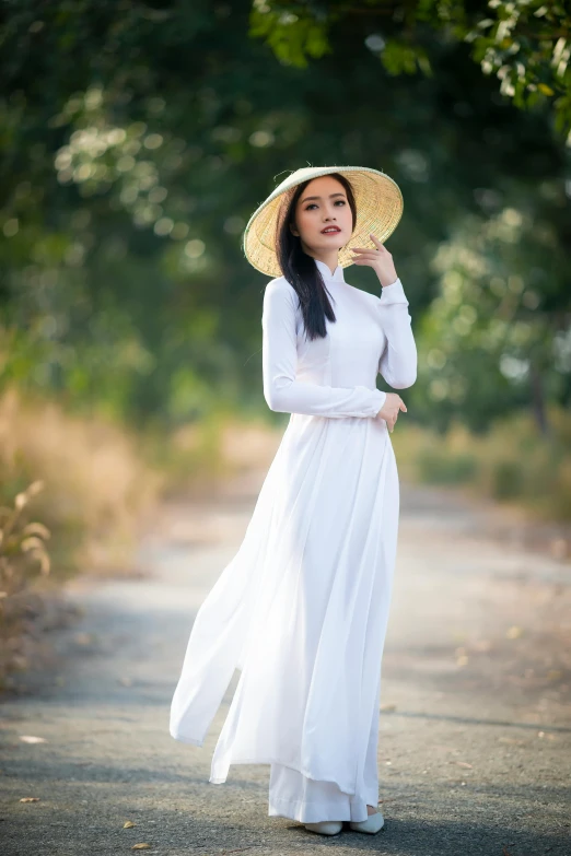 an asian woman is standing outside wearing a white dress