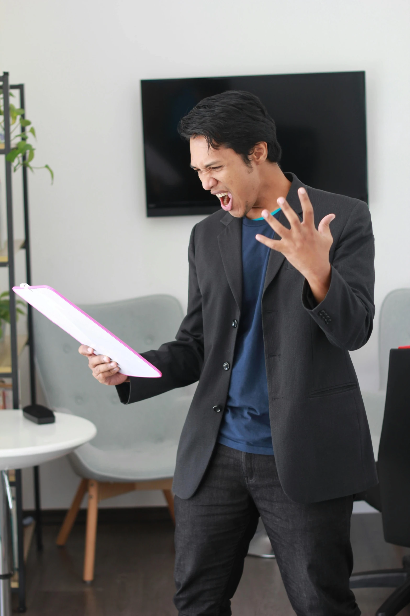 a man dressed in suit holds up a piece of paper