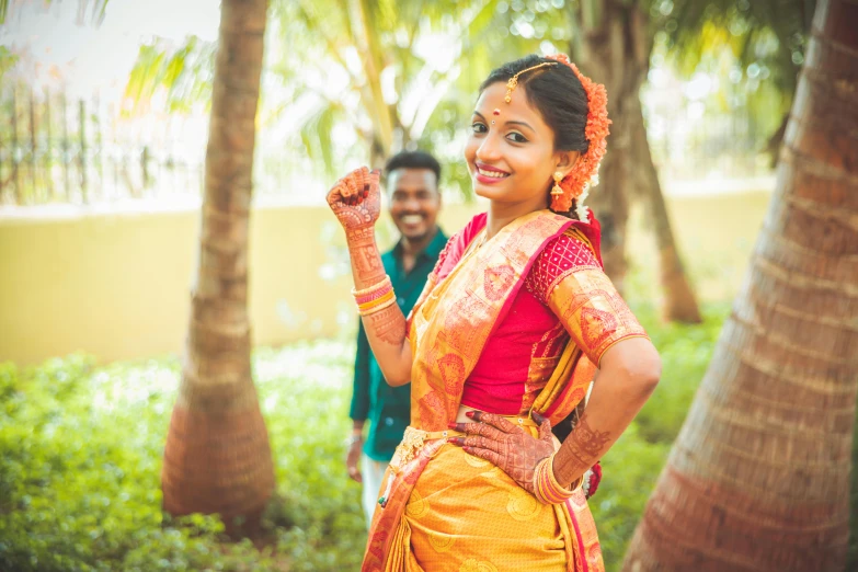 a happy couple in traditional indian clothing standing outdoors