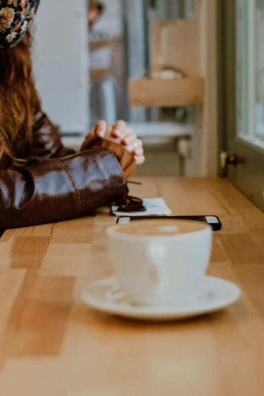a coffee mug and a woman sitting at a table
