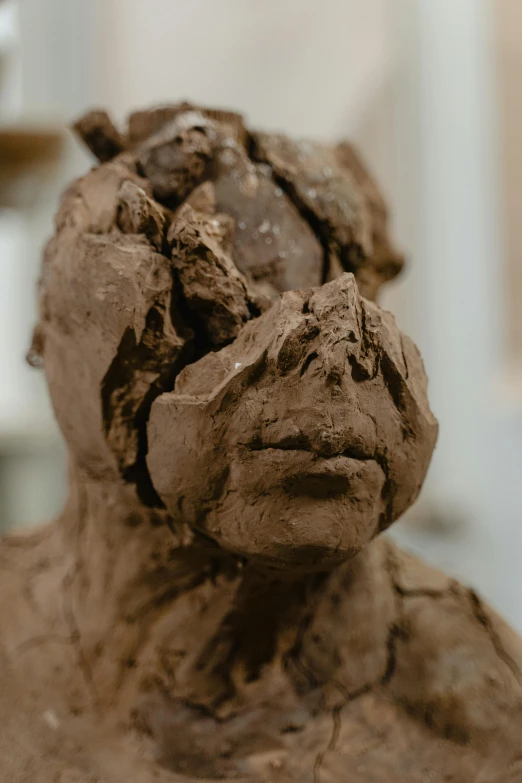 clay face sculpture with dark colors and various textures