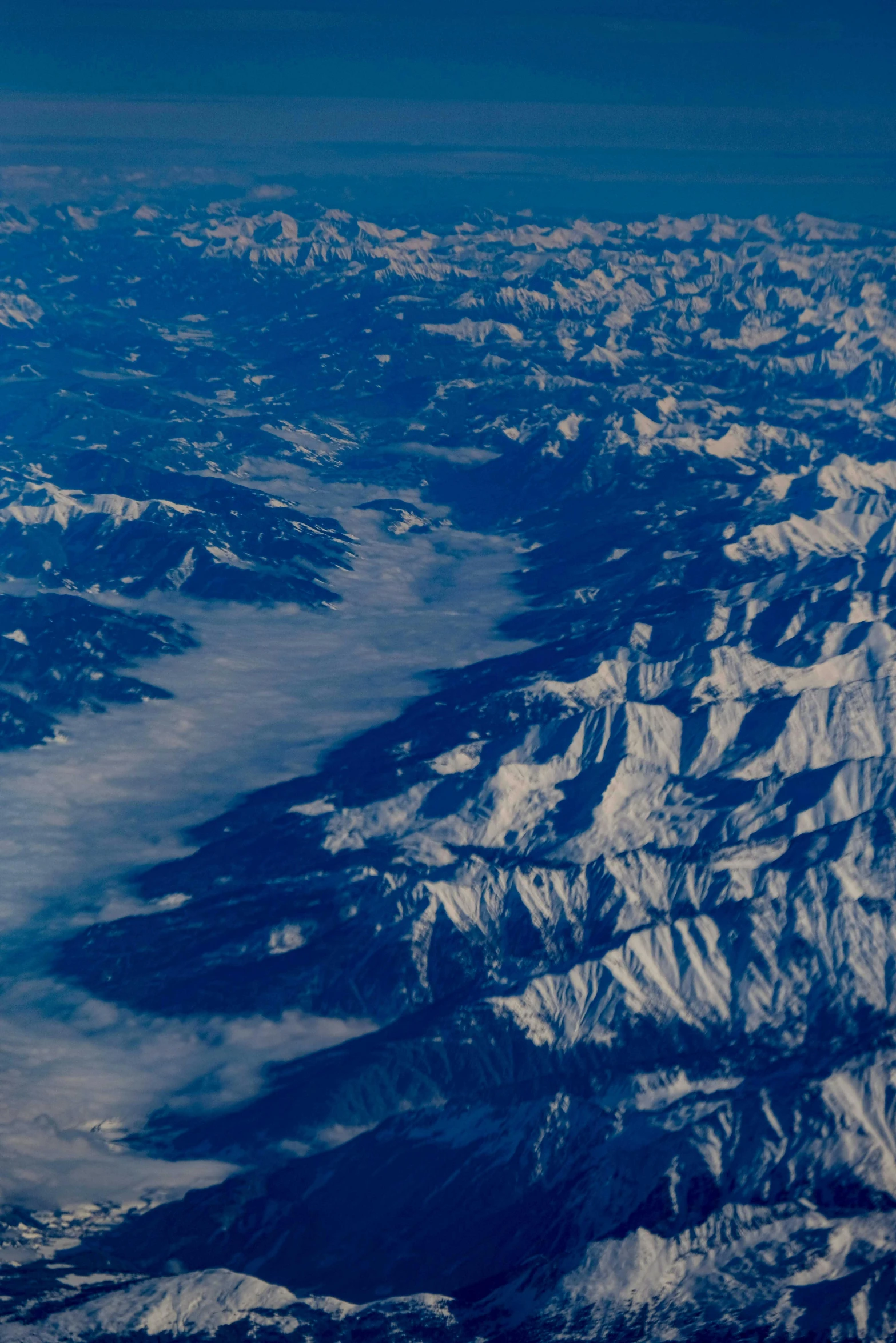 an airplane is flying over a big area of mountains