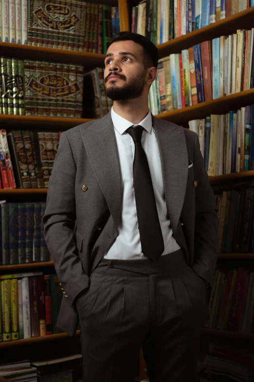 a man is standing in front of a bookcase